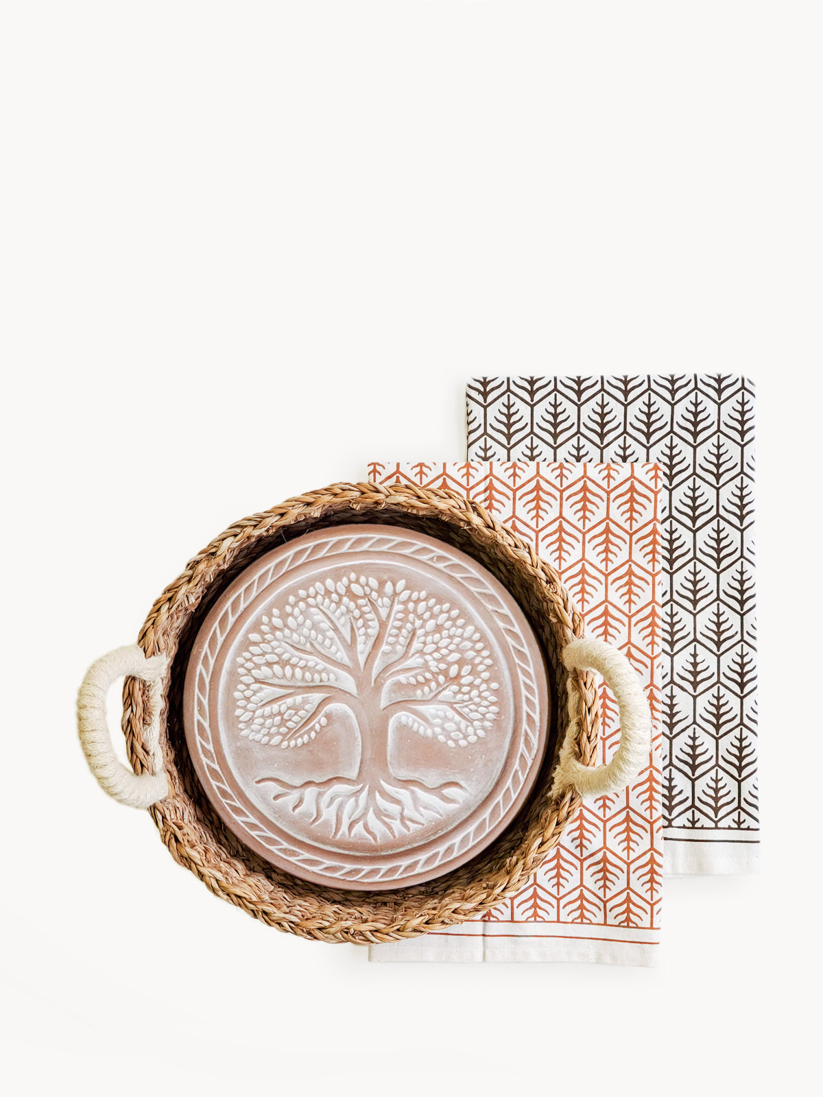 Decorative plate with tree design in a woven basket on a white background