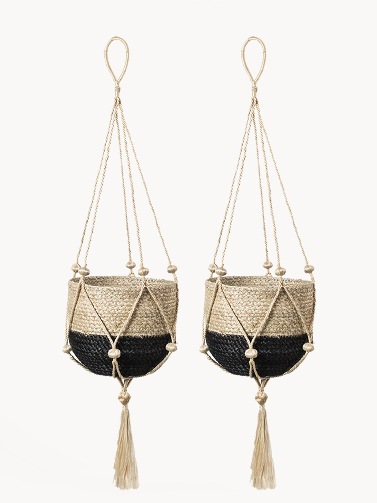 Two macrame plant hangers with black centers and tassels on a white background