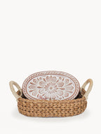 Decorative plate with floral design in a woven basket on a white background