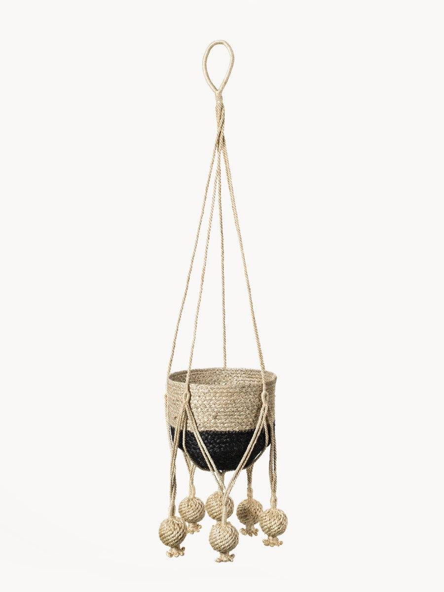 Woven plant hanger with decorative balls on a white background