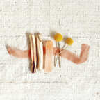 Decorative brooch with wooden elements and yellow flowers on a textured beige background