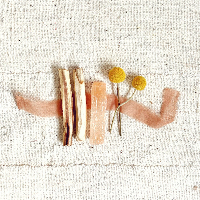 Decorative brooch with wooden elements and yellow flowers on a textured beige background