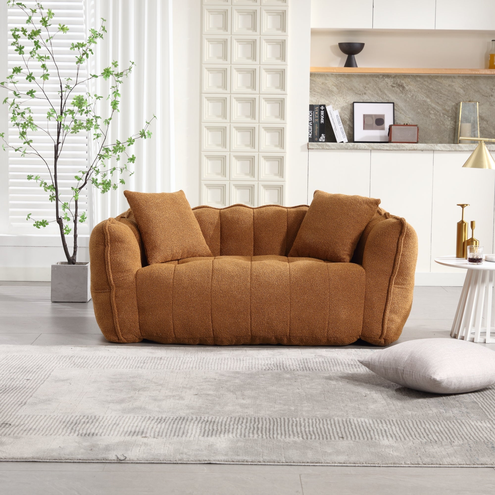 Brown sofa in a living room with a plant and shelves in the background