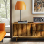 Modern living room with wooden cabinet, orange lamp, and books.