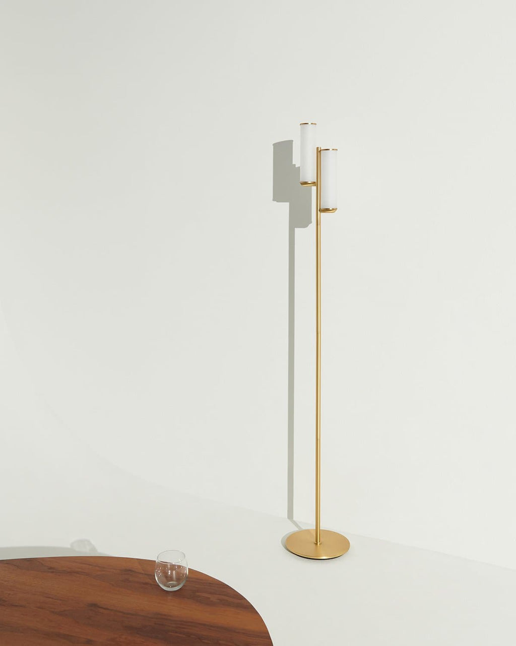 Modern floor lamp with a gold base on a white background