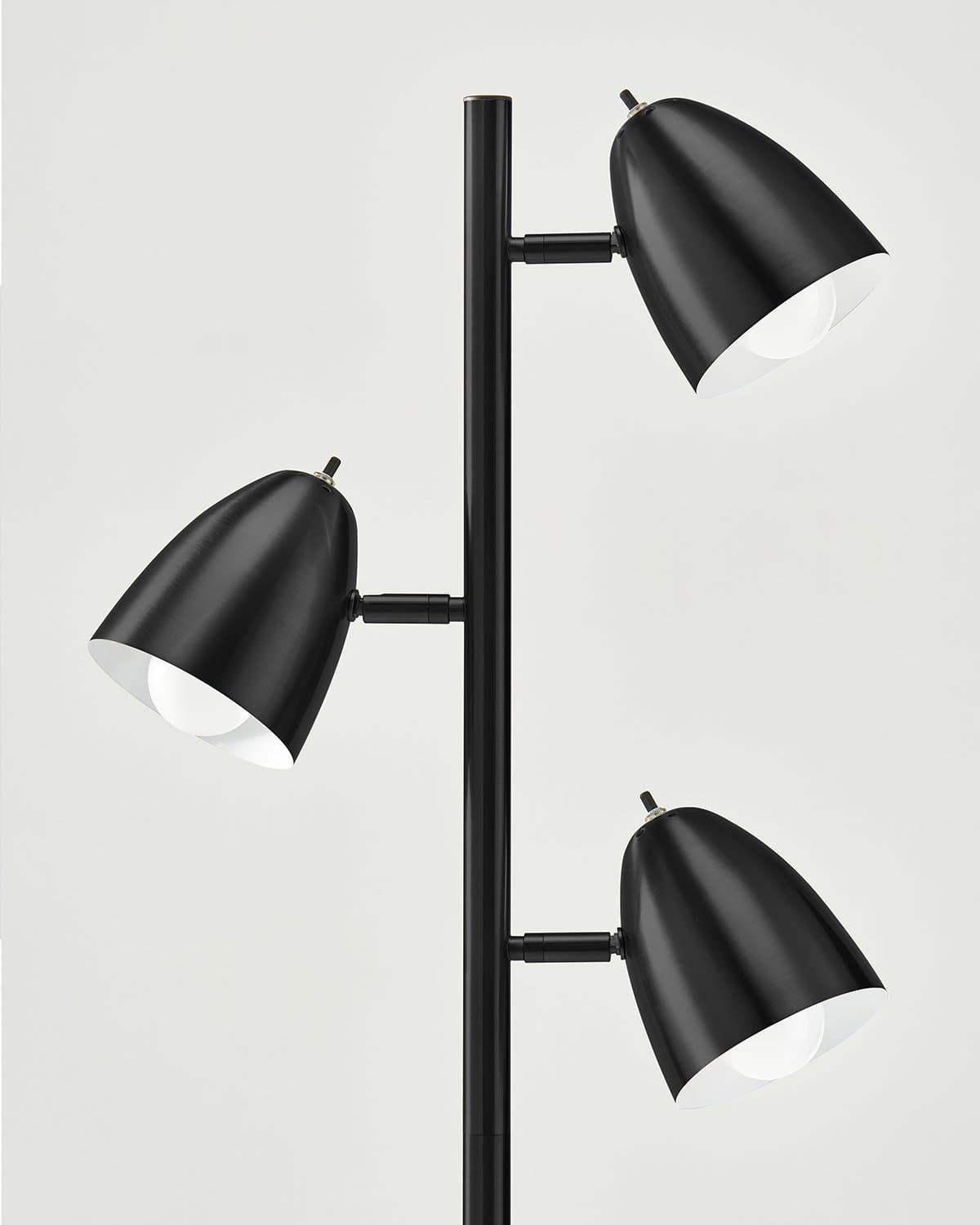 Black three-head floor lamp on a light gray background