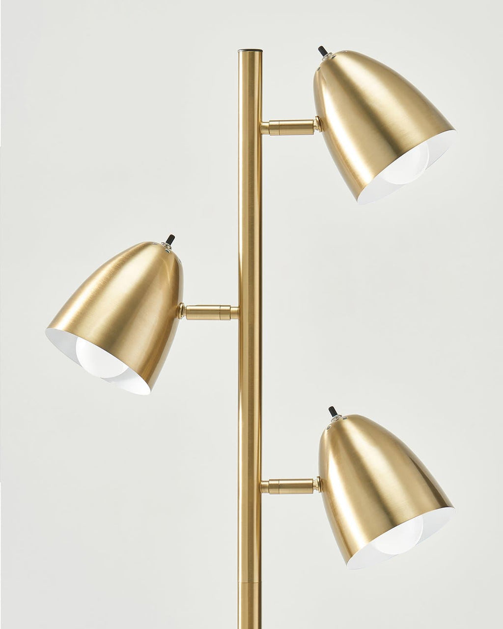 Gold floor lamp with three adjustable lights on a white background