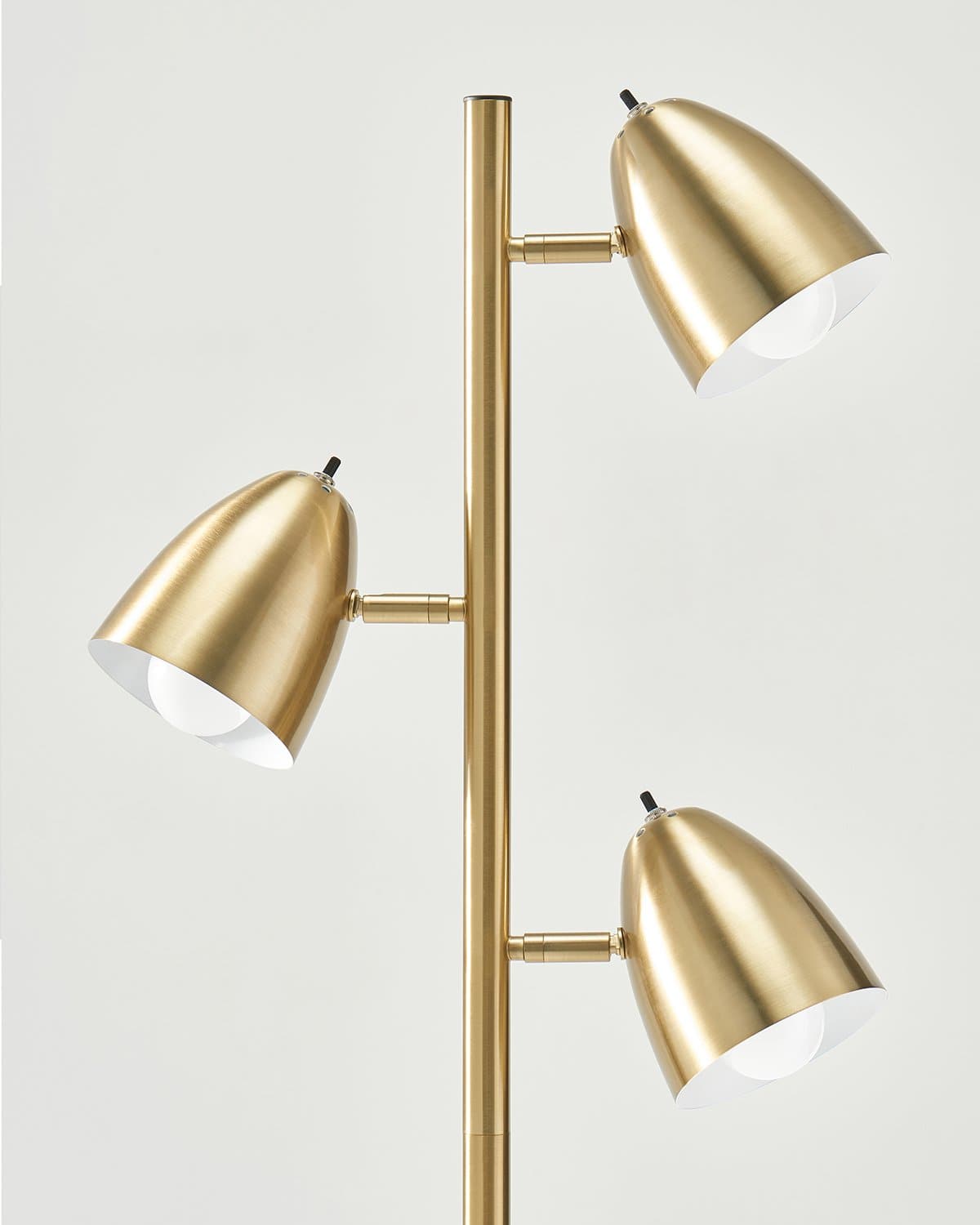 Gold floor lamp with three adjustable lights on a white background