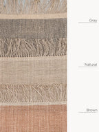 Textured fabric with fringes in gray, natural, and brown colors.