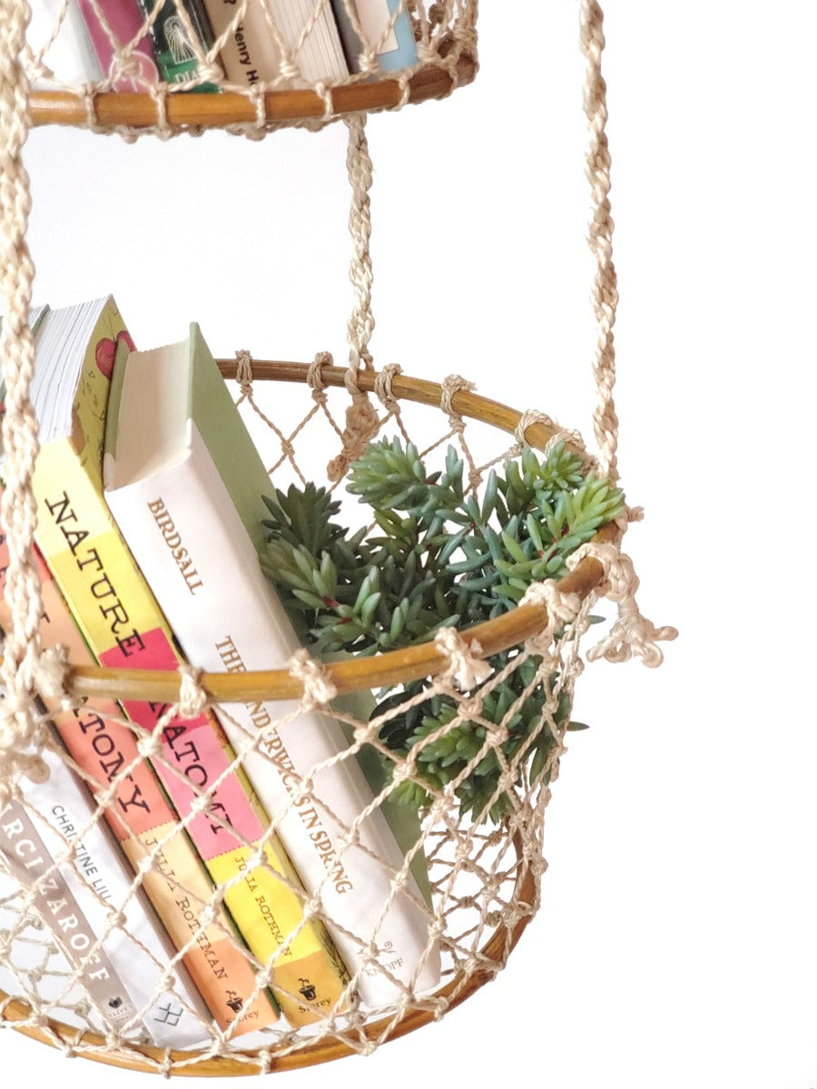 Hanging basket with books and a plant on a white background