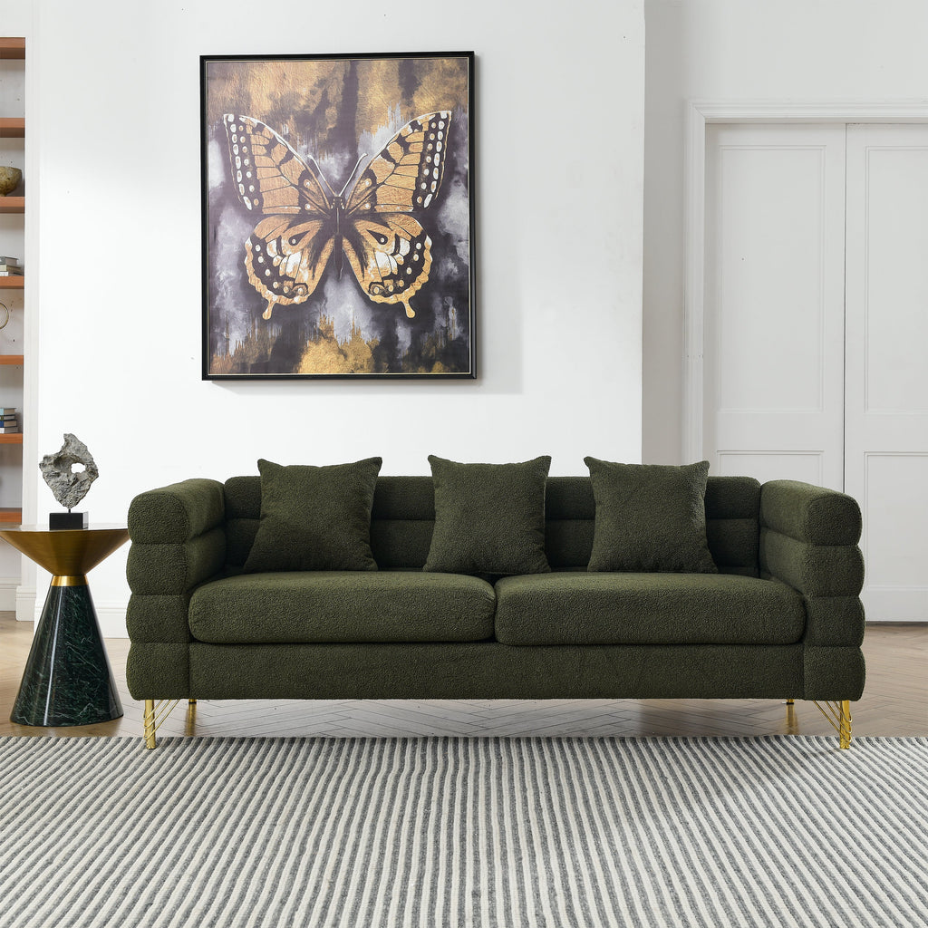 Green sofa in a living room with a butterfly painting on the wall.