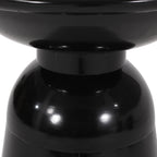 Close-up of a black cylindrical joint of side table with a reflective surface on a white background