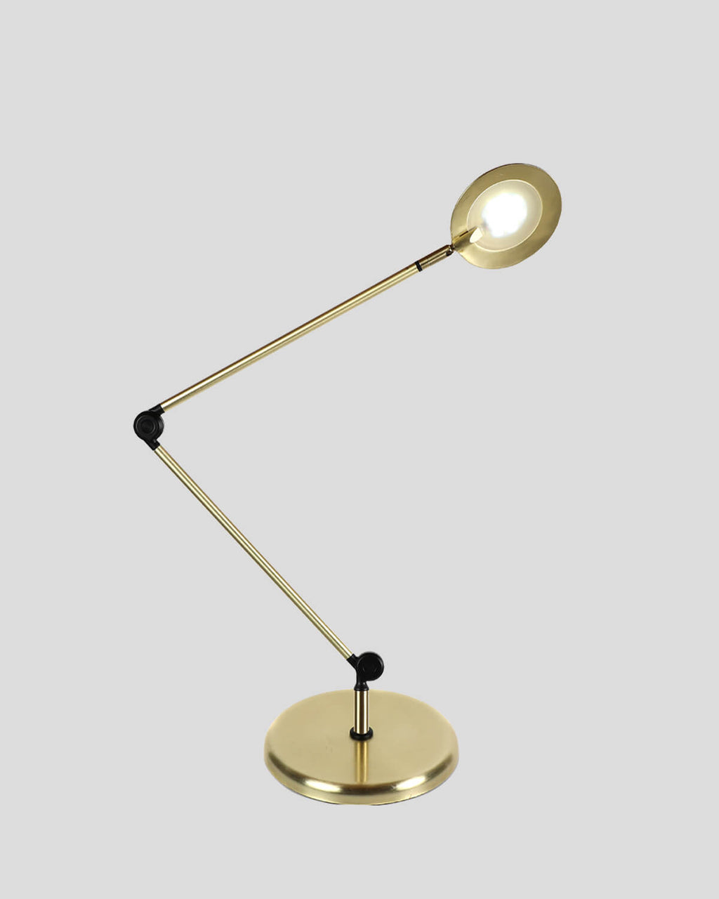 Gold adjustable desk lamp on a light gray background