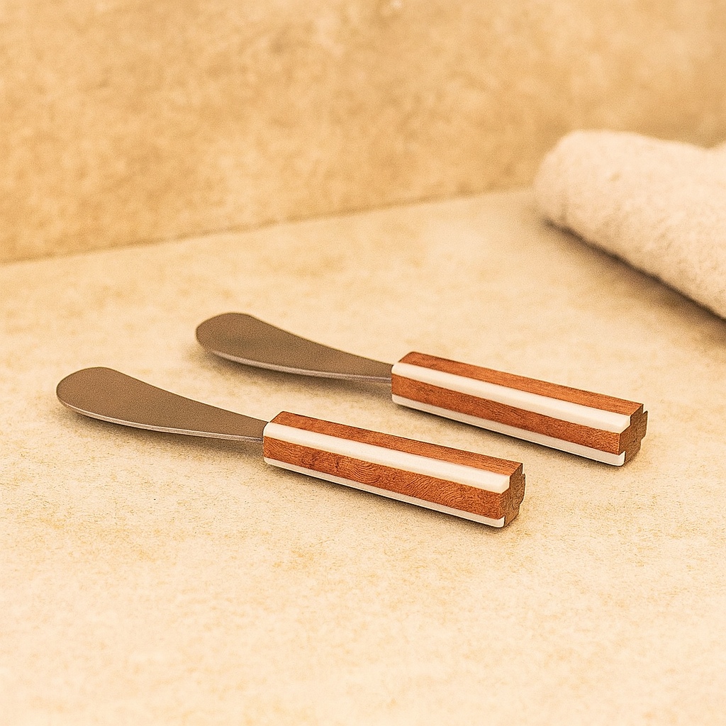 Two butter knives with wooden handles on a beige surface