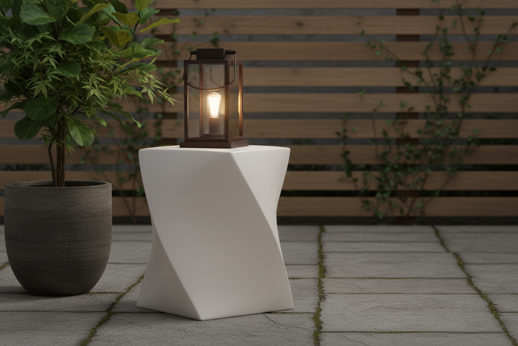 White outdoor side table with a lantern on a stone patio