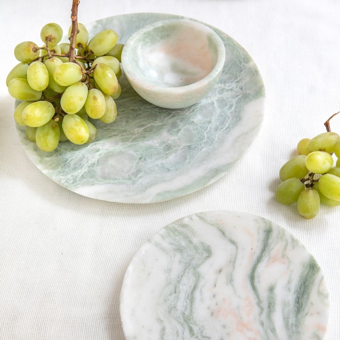 Marble-patterned plates with grapes on a white background