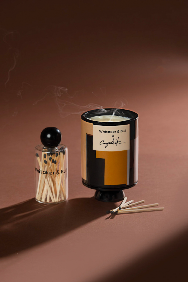 Candle and matches with a branded label on a brown background