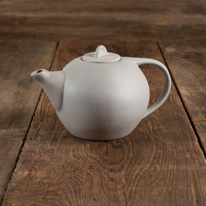 White ceramic teapot on a wooden surface