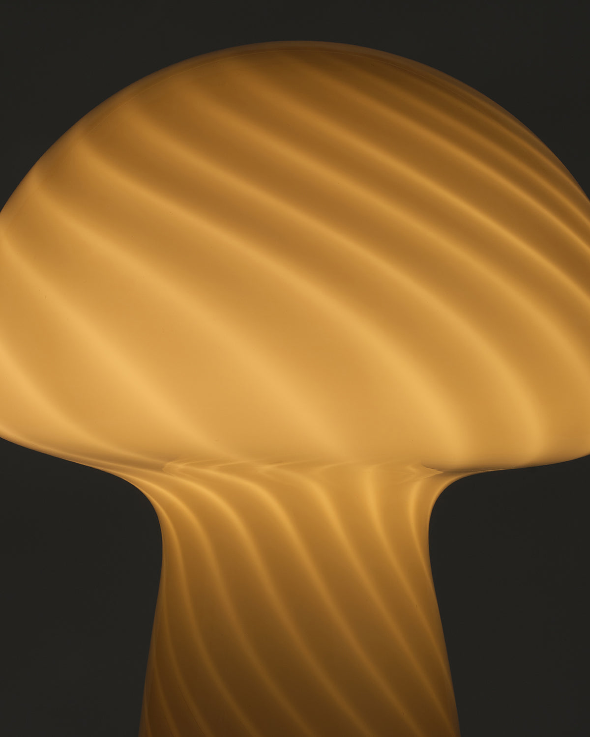 Close-up of a textured gold surface lamp with a dark background