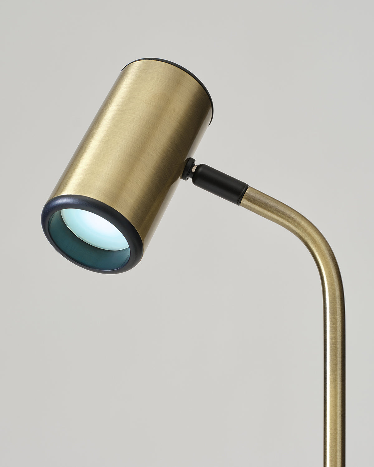 Gold table lamp with a cylindrical shade on a gray background