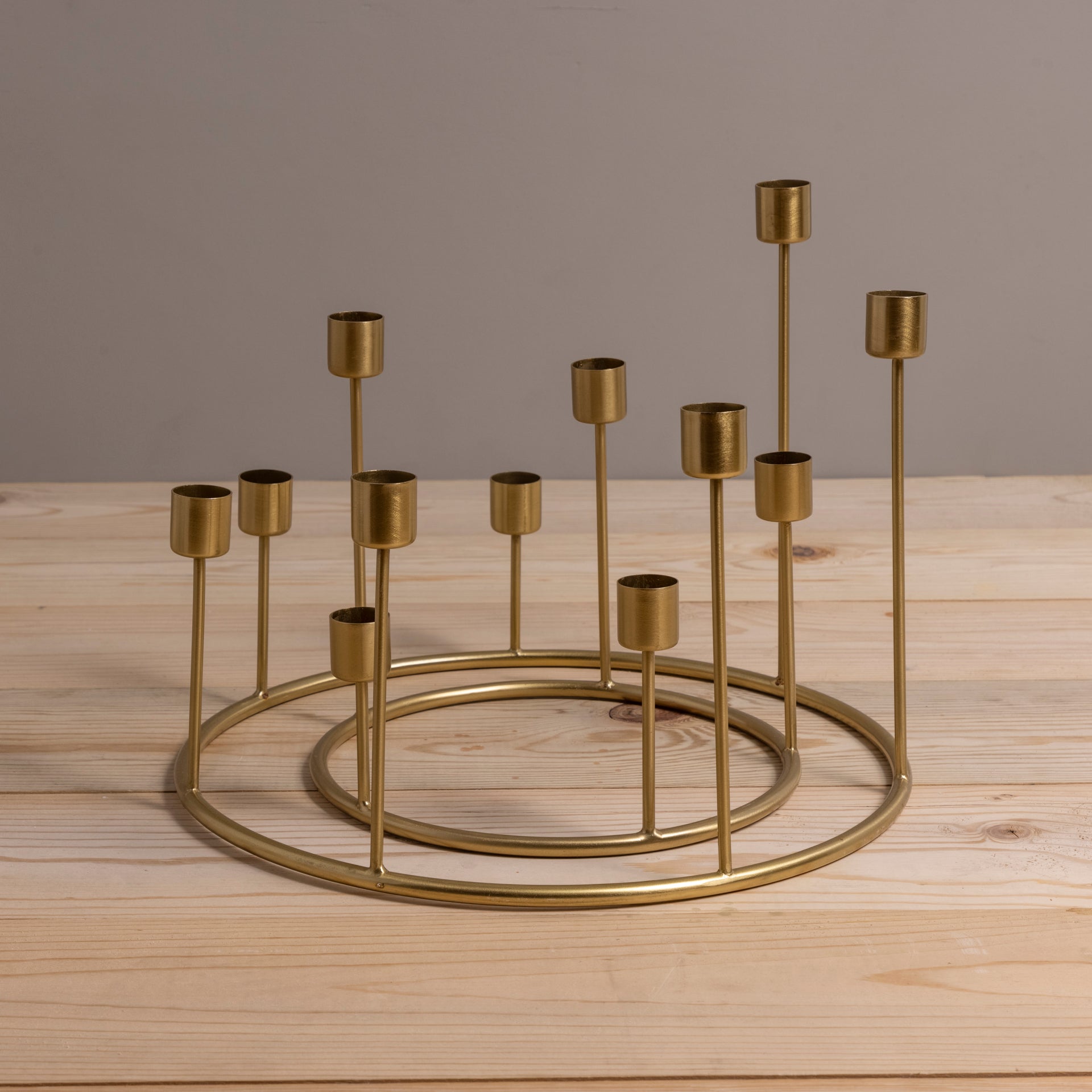 Gold metal candle holder with multiple small candles on a wooden surface
