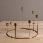 Gold candle holder with multiple small candle holders on a wooden surface