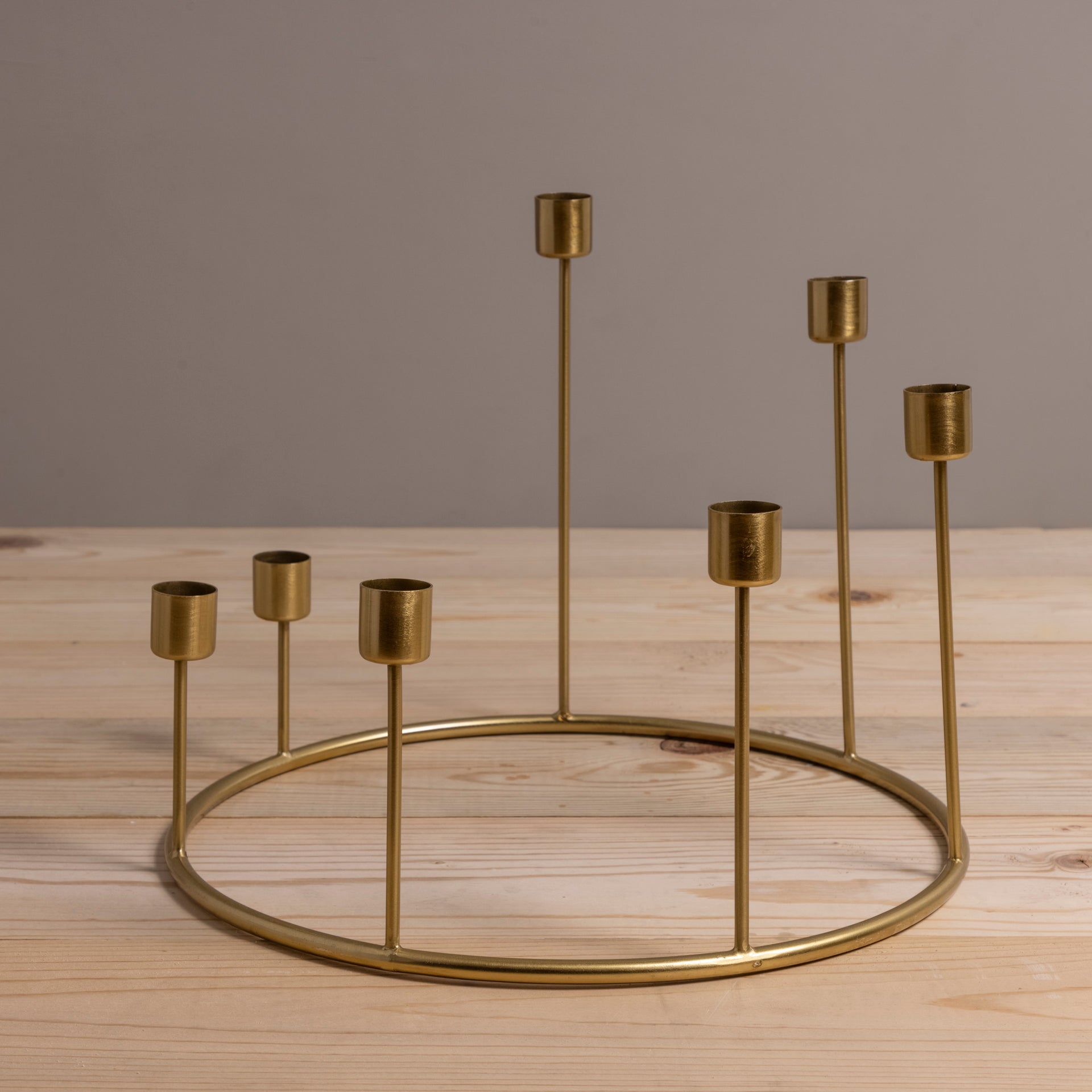 Gold candle holder with multiple small candle holders on a wooden surface