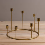 Gold candle holder with multiple small candle holders on a wooden surface