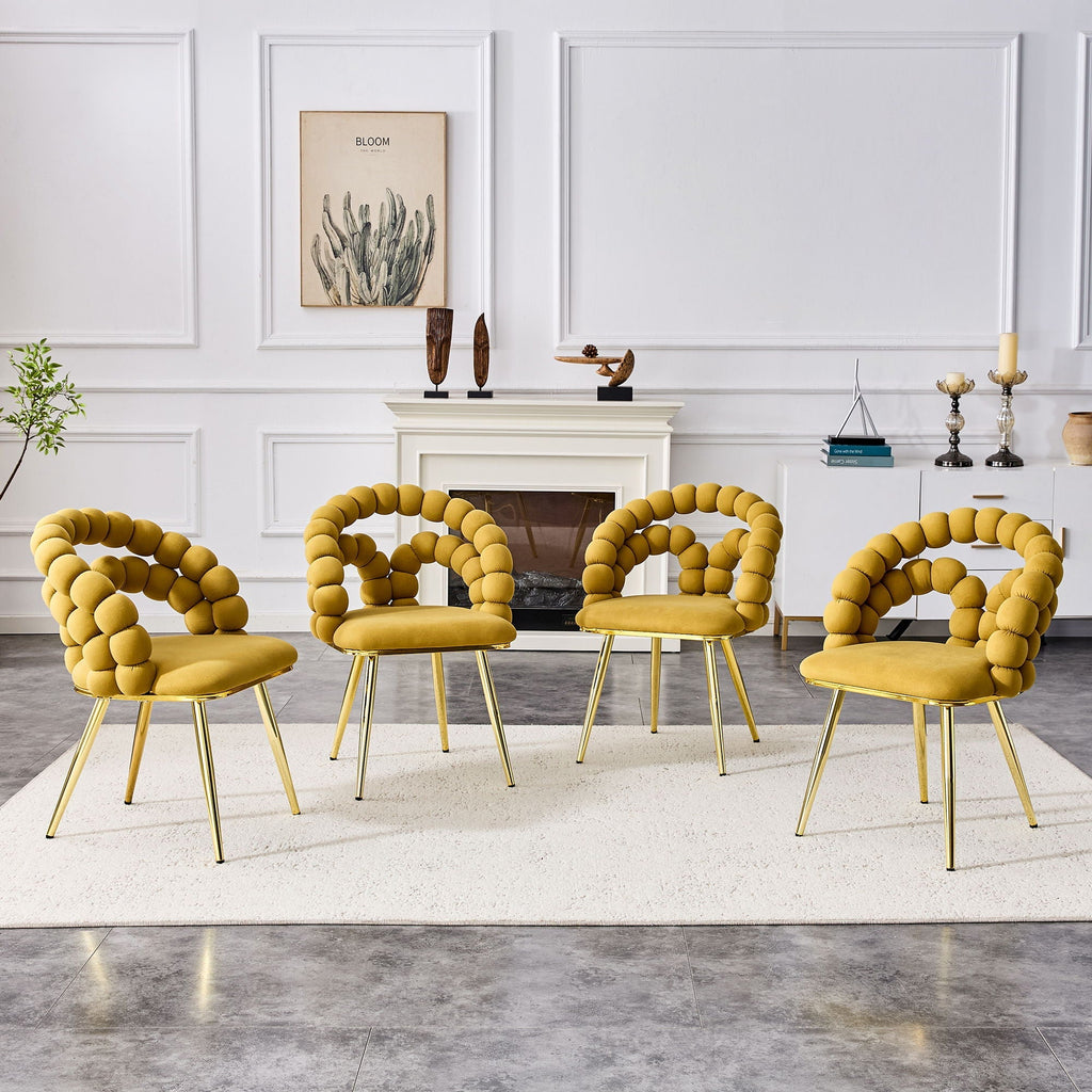 Four yellow chairs with gold legs arranged in a circle in a living room setting.