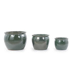 Three dark green glazed ceramic planters in graduated sizes, arranged from left to right on a plain white background.