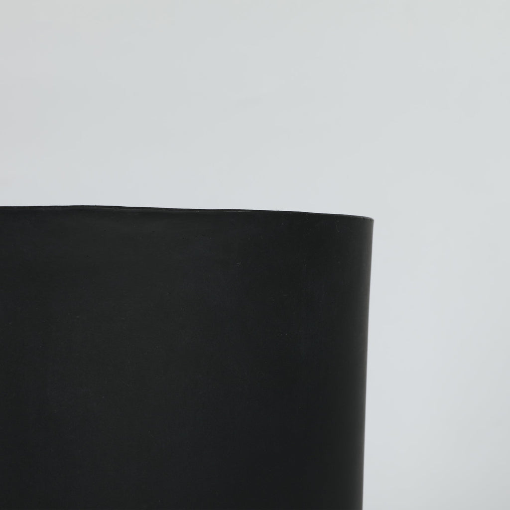 Black cylindrical planter on a light gray background