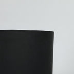 Black cylindrical planter on a light gray background