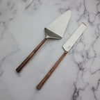 Two cake knives with copper handles on a marble surface
