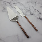 Two cake knives with copper handles on a marble surface