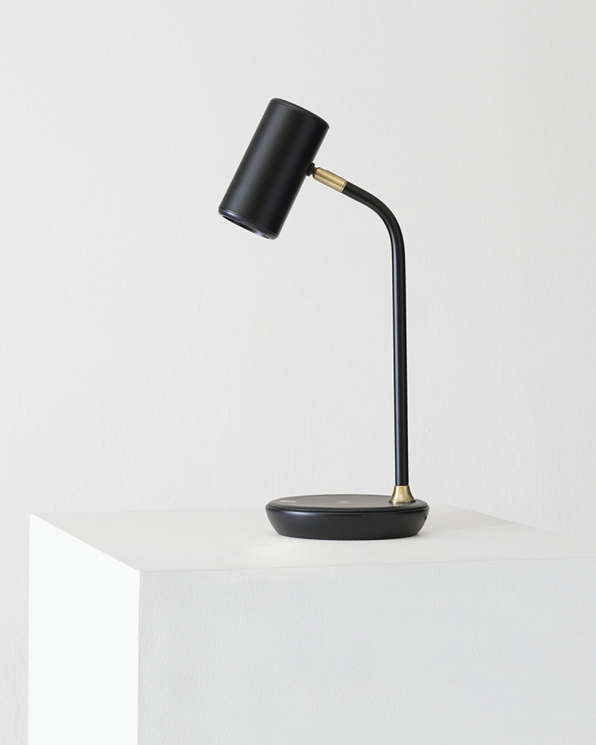 Black desk lamp with a gold accent on a white background