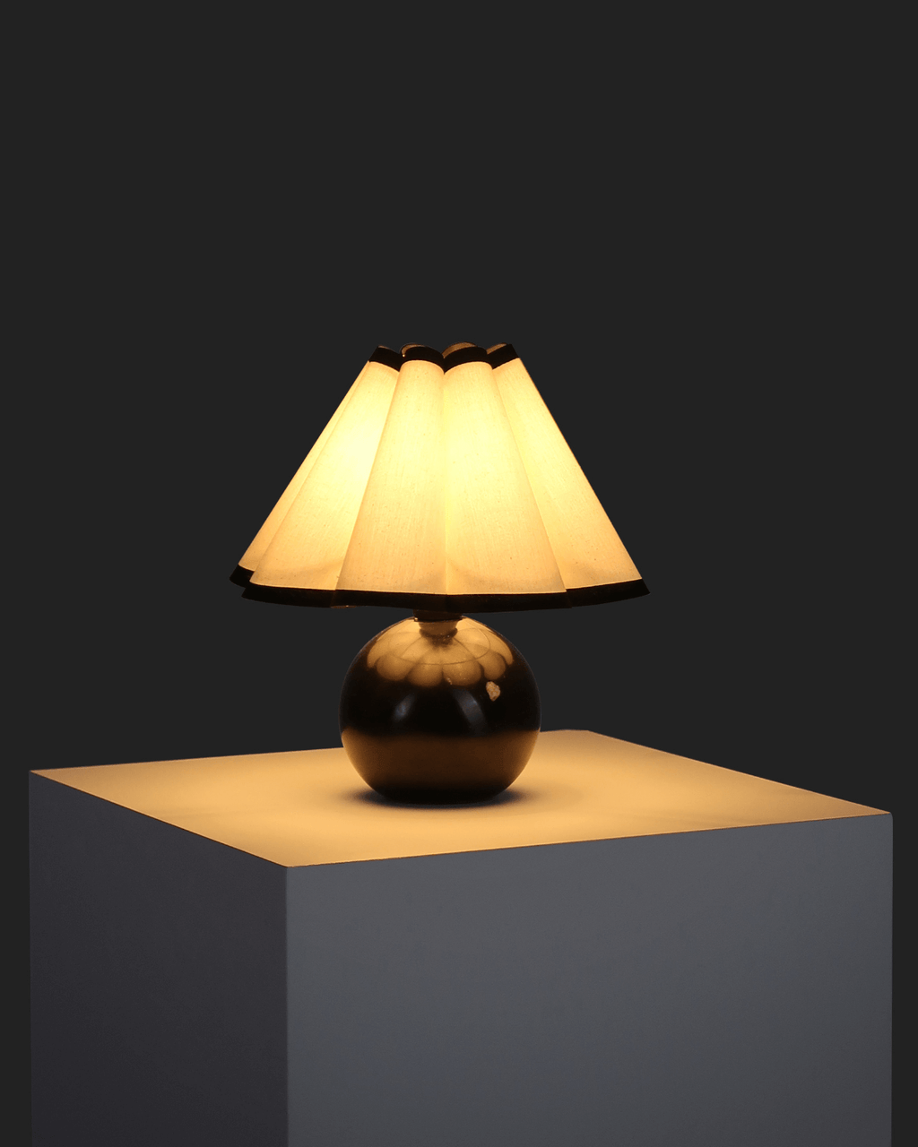 Table lamp with a beige shade on a dark background