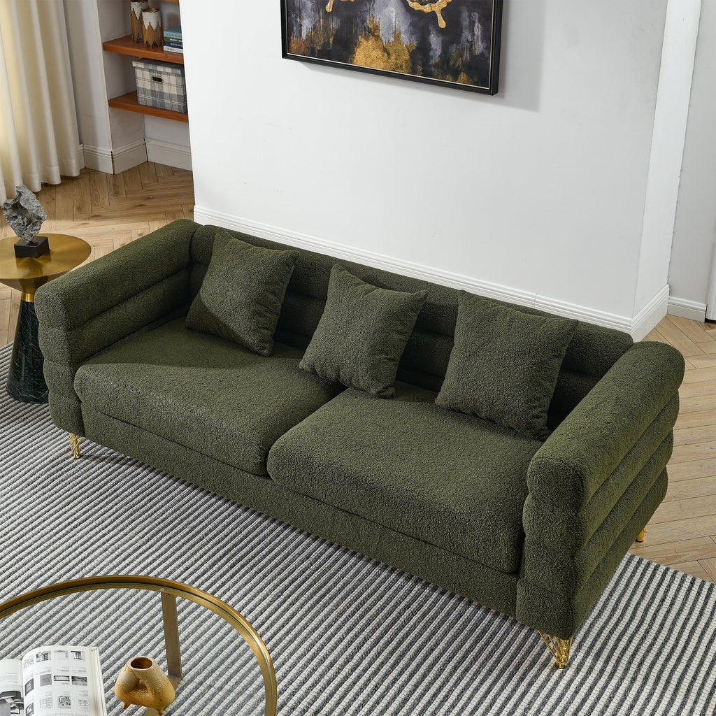 Green sofa in a living room setting with a rug and side table.