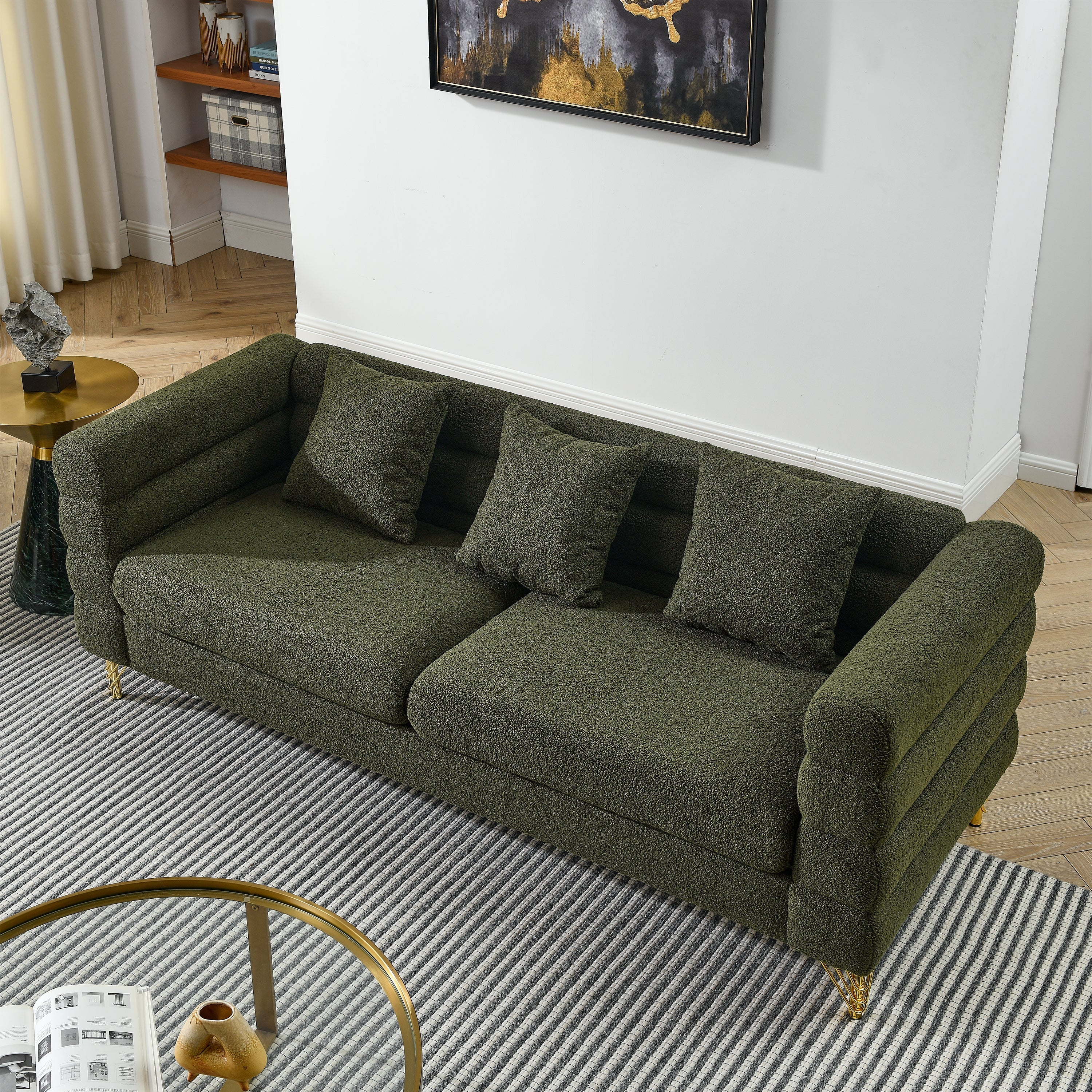 Green sofa in a living room setting with a rug and side table.