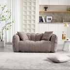 Gray sofa in a modern living room with a plant and shelves in the background.