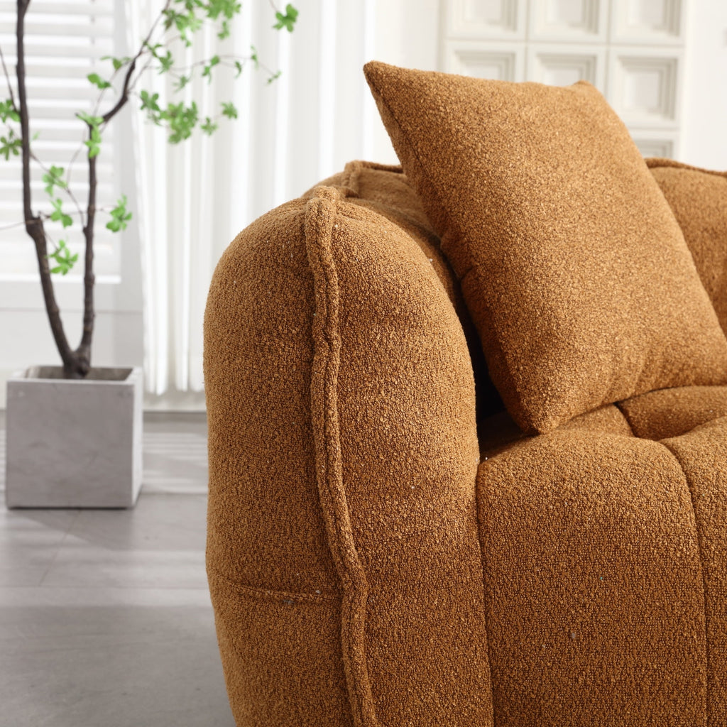 Brown textured sofa with a pillow in a room with a plant and window blinds.