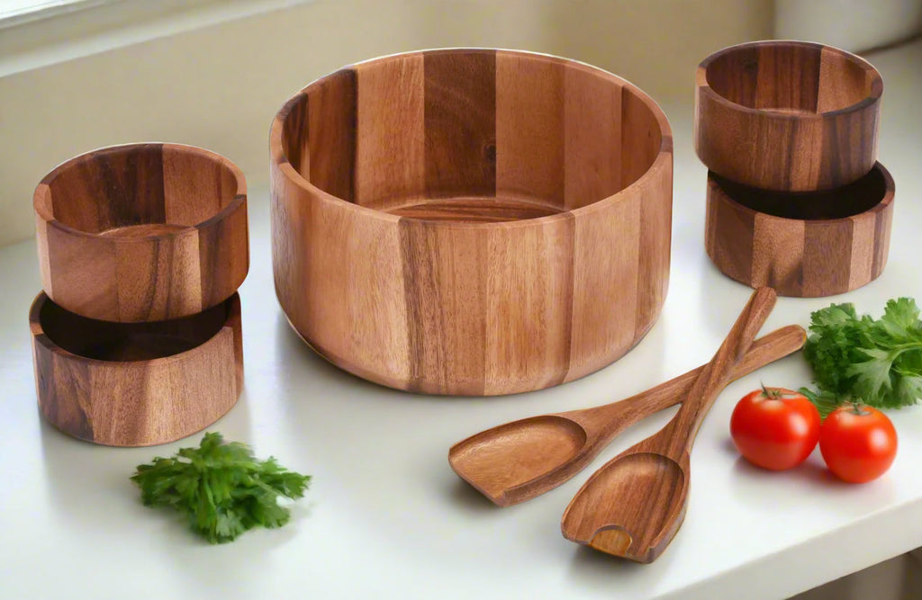 Wooden kitchenware set including a bowl, cups, and spoons on a white surface with vegetables.