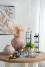 Decorative table setting with vases, lanterns, and a fish figurine in a home interior.
