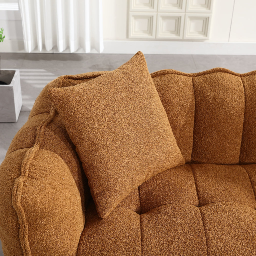 Brown textured sofa with a matching pillow in a room with light-colored walls and a plant.