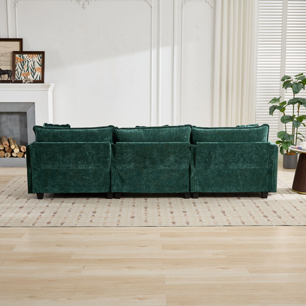 Green sofa in a living room setting with a fireplace and plants.