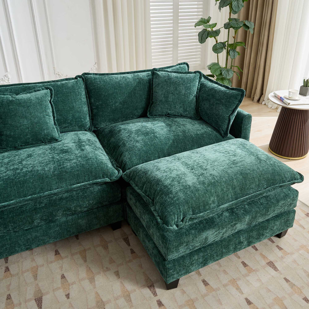 Green velvet sectional sofa in a living room setting with a plant and side table.