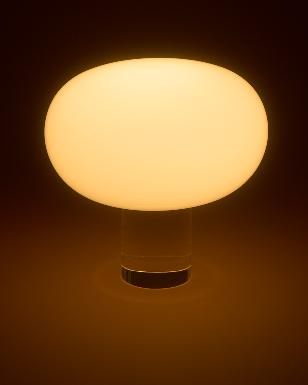 Round table lamp with a warm glow on a dark background