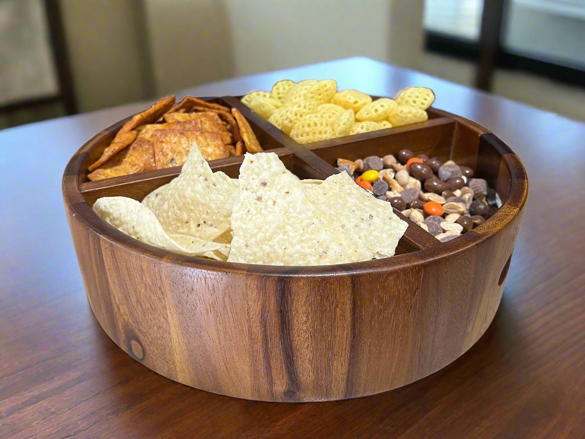 Wooden snack platter with various chips and crackers on a wooden table.