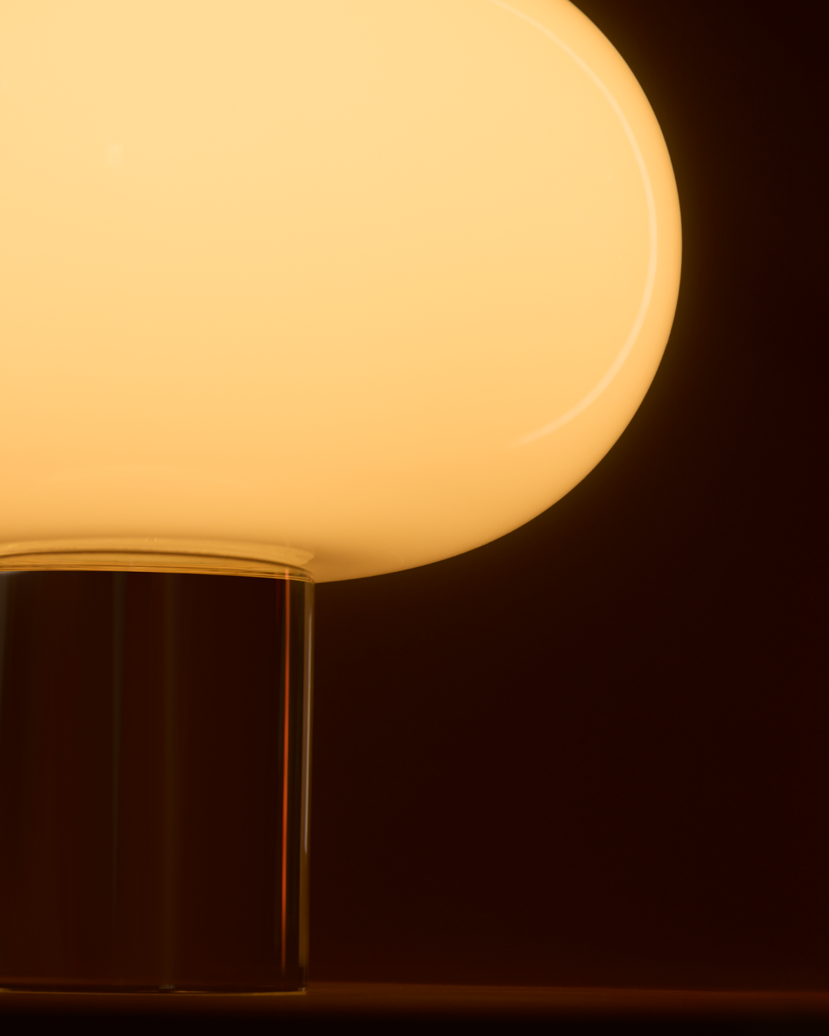 Close-up of a glowing lamp with a glass base against a dark background