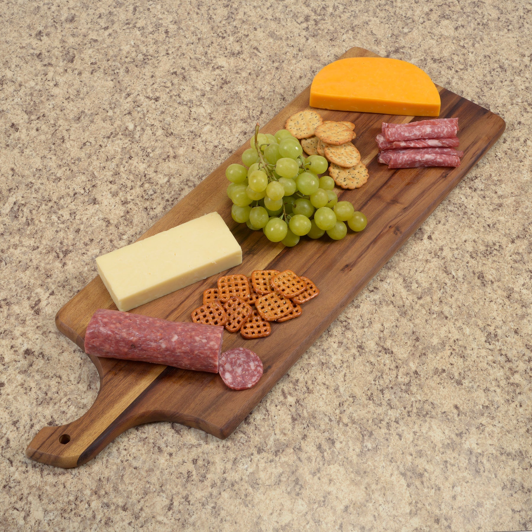 Wooden charcuterie board with cheese, grapes, and salami on a beige countertop