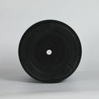 Black planter bottom with a hole on a light gray background